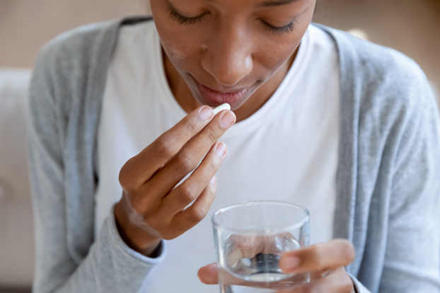 Young Black woman taking tablet