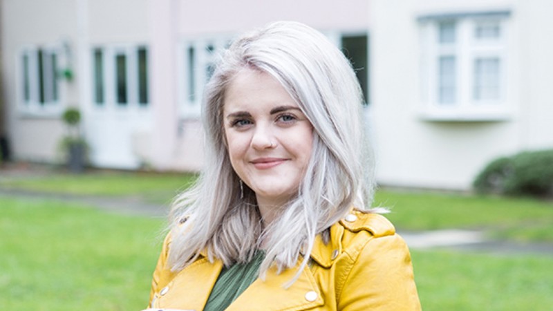 Rhiannon with houses behind her