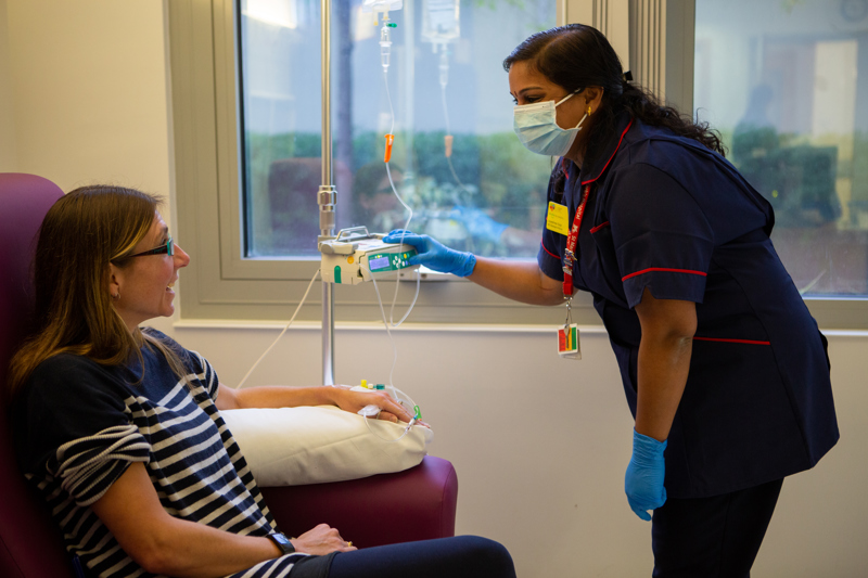 Woman having infusion chatting with nurse