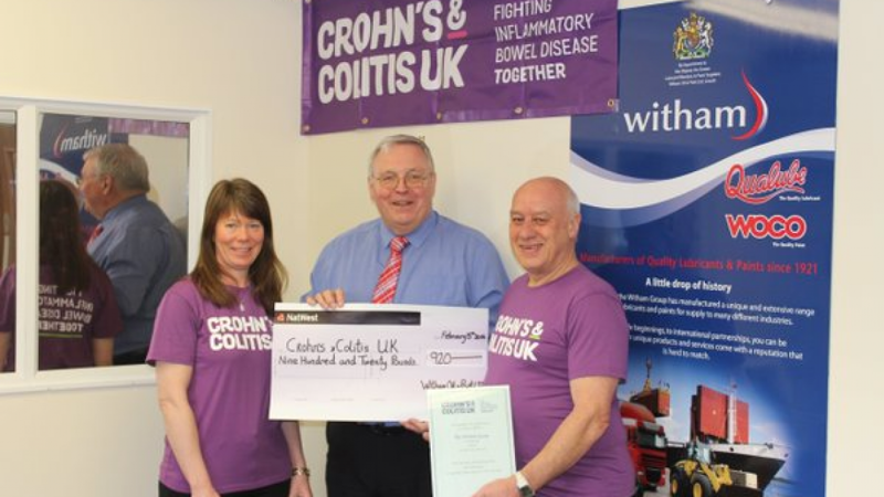 Crohn's & Colitis UK supporters wearing purple t-shirts being presented with a cheque